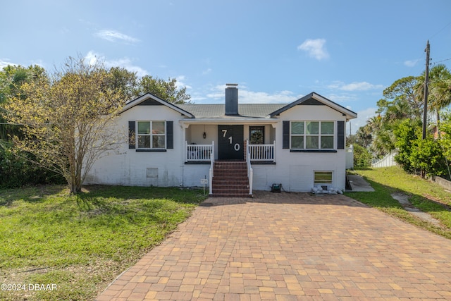 view of front of property with covered porch and a front yard