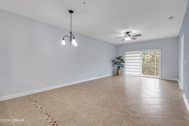 empty room featuring ceiling fan with notable chandelier and light tile patterned floors