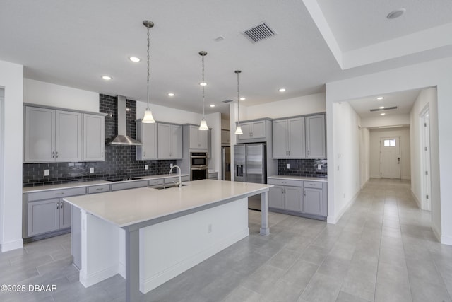 1316 Loftwedge Cir, Daytona Beach, FL 32124 - kitchen with wall chimney exhaust hood, gray cabinets, appliances with stainless steel finishes, backsplash, and a large island with sink