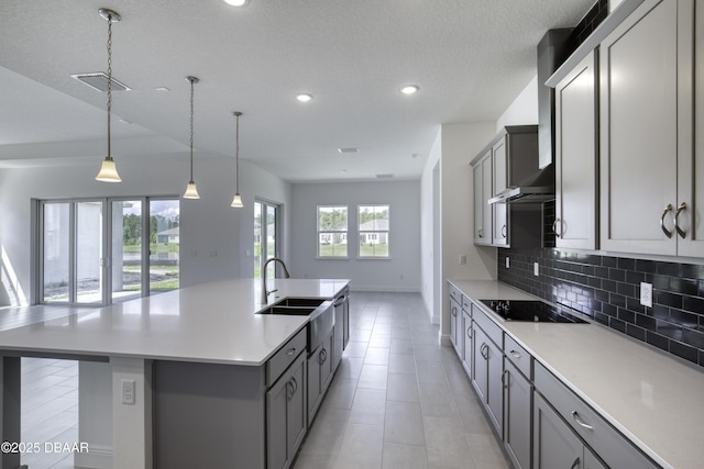 1316 Loftwedge Cir, Daytona Beach, FL 32124 - kitchen featuring black electric cooktop, gray cabinetry, wall chimney range hood, tasteful backsplash, and recessed lighting