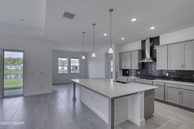 1316 Loftwedge Cir, Daytona Beach, FL 32124 - kitchen featuring wall chimney exhaust hood, gray cabinetry, light countertops, decorative backsplash, and an island with sink