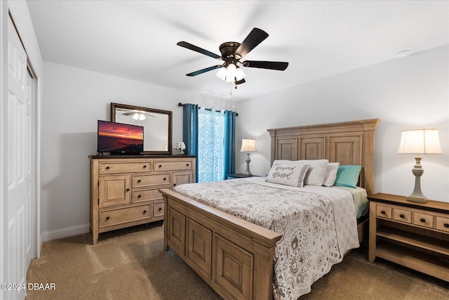 carpeted bedroom featuring ceiling fan and a closet