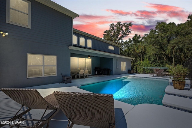 pool at dusk with a patio