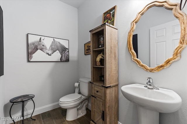 bathroom featuring toilet, sink, and hardwood / wood-style floors