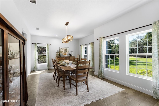 dining room with light wood-type flooring and an inviting chandelier