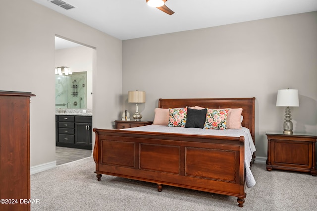 carpeted bedroom with ensuite bathroom, sink, and ceiling fan