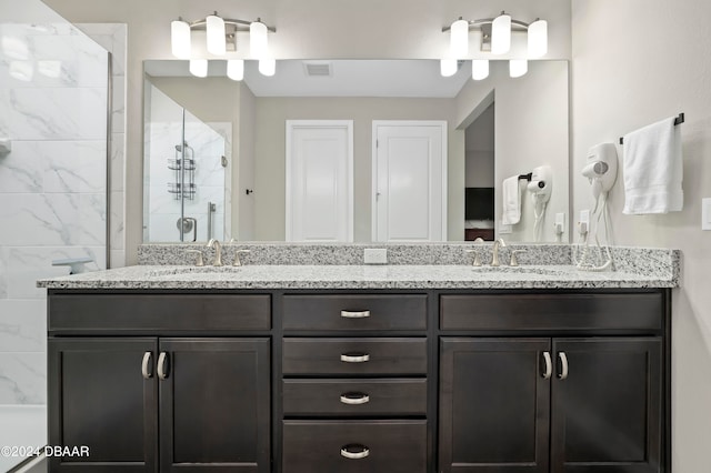 bathroom with vanity and a tile shower