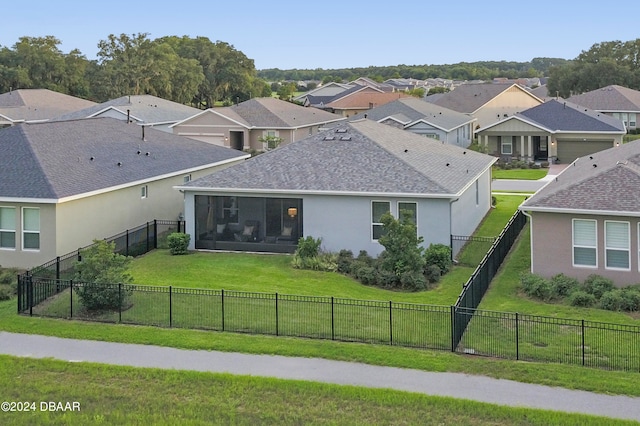 rear view of property with a yard and a sunroom