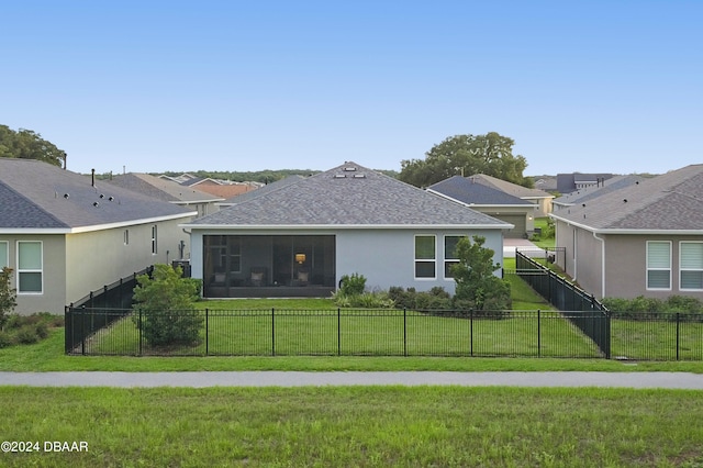 back of property with a lawn and a sunroom