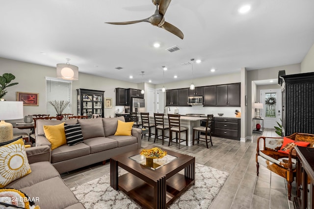 living room with light hardwood / wood-style flooring and ceiling fan