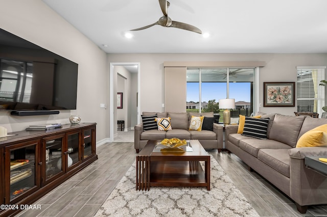 living room with light hardwood / wood-style flooring and ceiling fan