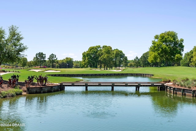 dock area with a lawn and a water view