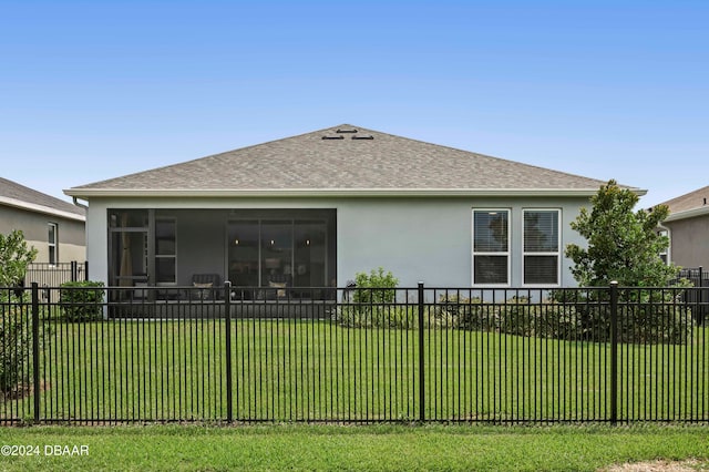 back of house featuring a sunroom and a lawn