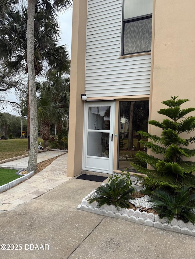 doorway to property featuring stucco siding