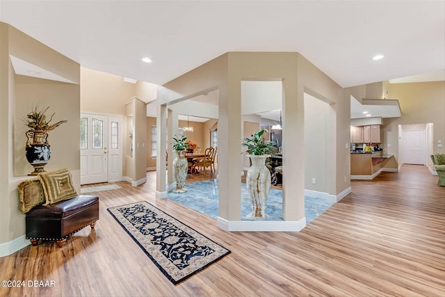 foyer with an inviting chandelier and light wood-type flooring