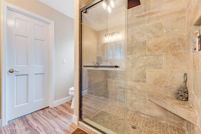 bathroom with walk in shower, hardwood / wood-style flooring, and toilet