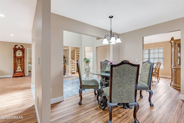 dining area with a chandelier and light hardwood / wood-style flooring