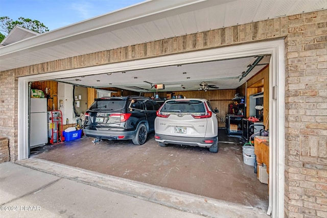 garage with a garage door opener and white refrigerator