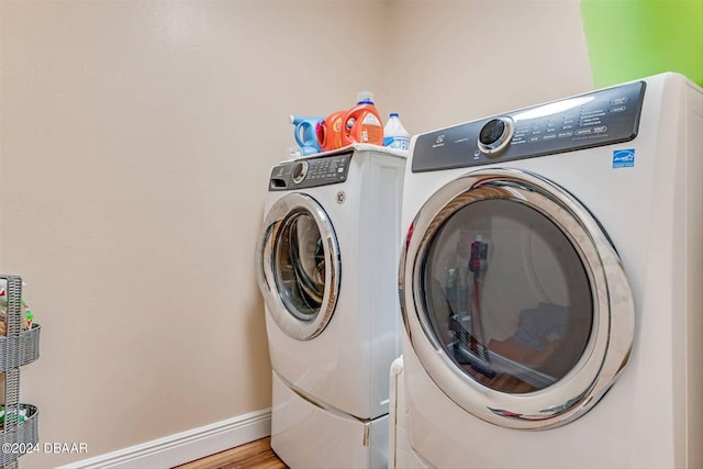 clothes washing area featuring light hardwood / wood-style floors and separate washer and dryer