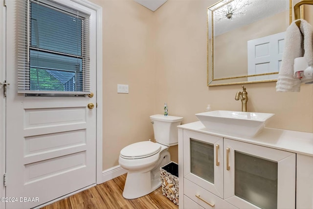 bathroom with hardwood / wood-style floors, vanity, and toilet