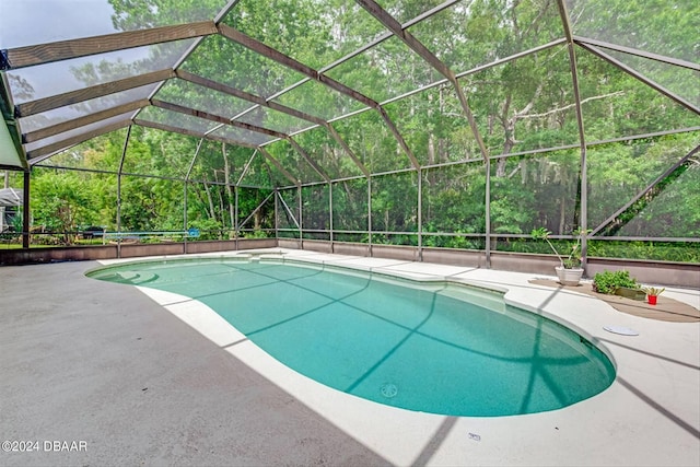 view of pool featuring glass enclosure and a patio