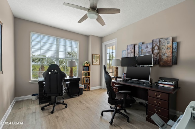 home office with a textured ceiling, ceiling fan, and light hardwood / wood-style flooring