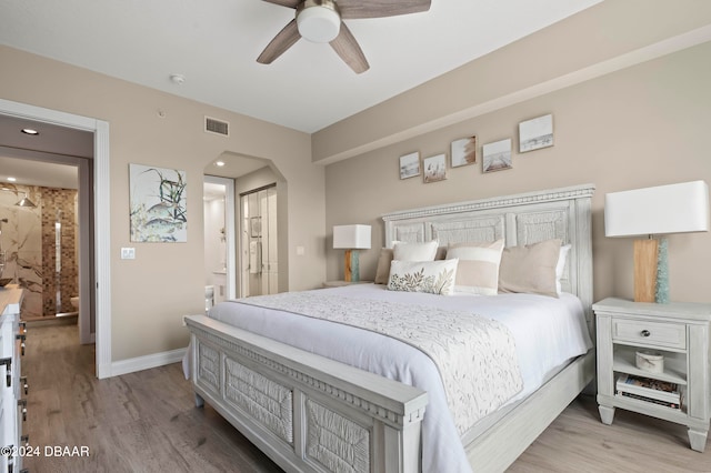 bedroom with ceiling fan, ensuite bathroom, and wood-type flooring