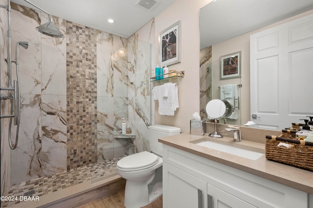 bathroom with wood-type flooring, vanity, a shower with door, and toilet