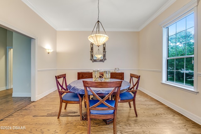 dining area with light hardwood / wood-style floors, a healthy amount of sunlight, and crown molding