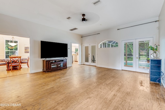 living room featuring ceiling fan, light hardwood / wood-style flooring, and french doors