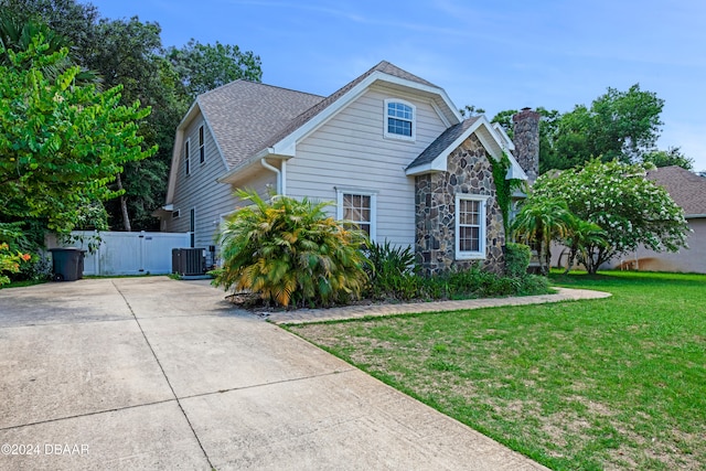 view of front facade featuring cooling unit and a front yard