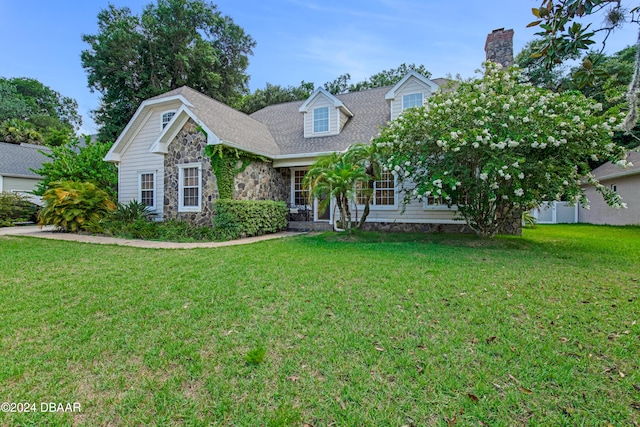 cape cod home featuring a front lawn