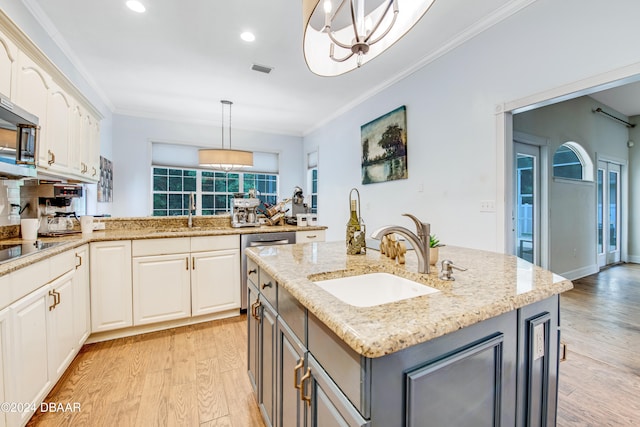 kitchen with hanging light fixtures, sink, gray cabinetry, an island with sink, and light wood-type flooring