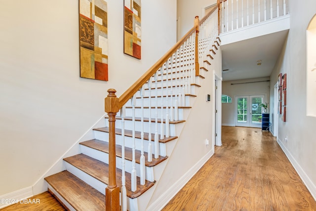 stairway featuring wood-type flooring and french doors