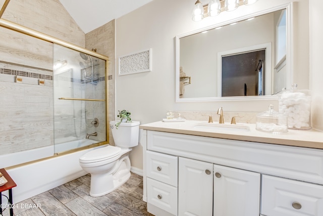 full bathroom with toilet, vanity, combined bath / shower with glass door, and lofted ceiling