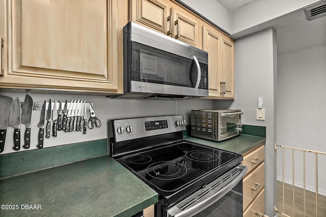 2987 S Atlantic Ave Unit 901, Daytona Beach Shores, FL 32118 - kitchen featuring appliances with stainless steel finishes, dark countertops, and light brown cabinets