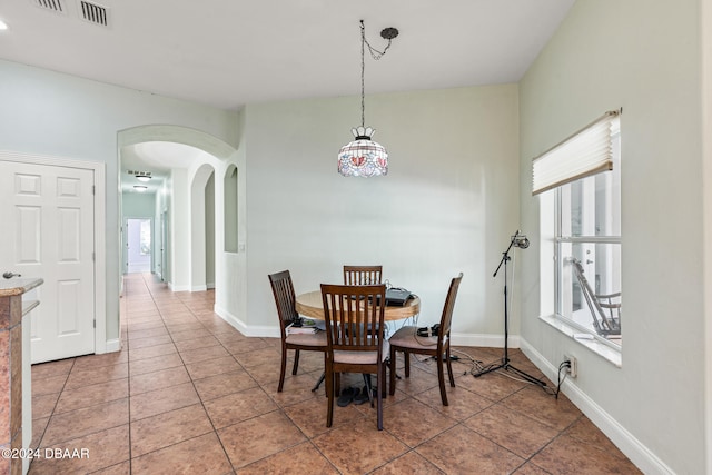 tiled dining space featuring a healthy amount of sunlight