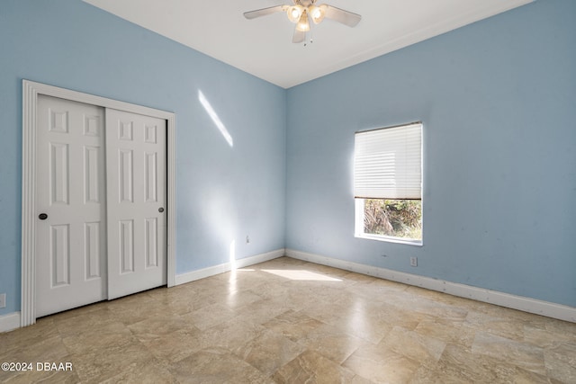 unfurnished bedroom with ceiling fan and a closet