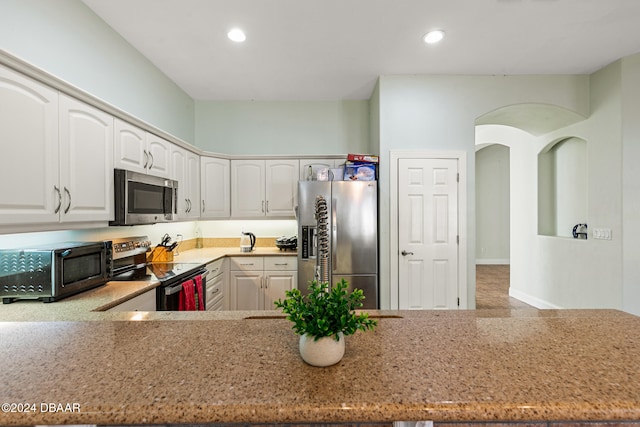 kitchen featuring white cabinetry, stainless steel appliances, and kitchen peninsula