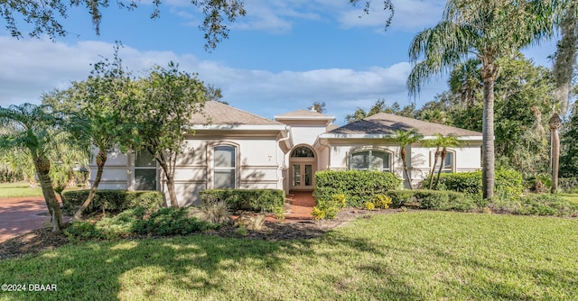 mediterranean / spanish home featuring french doors and a front yard