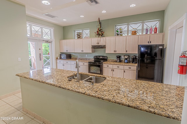 kitchen featuring sink, light stone counters, black appliances, light tile patterned flooring, and french doors