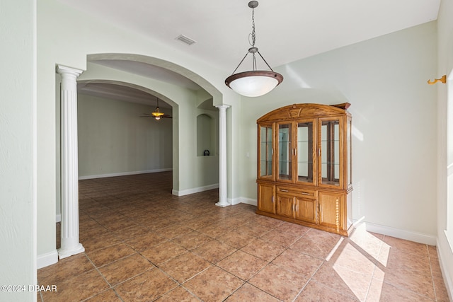 interior space with tile patterned floors, ceiling fan, and ornate columns