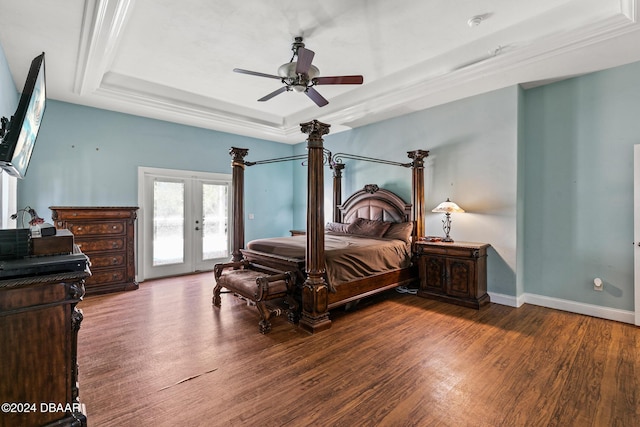 bedroom featuring dark hardwood / wood-style floors, access to outside, ceiling fan, a tray ceiling, and french doors