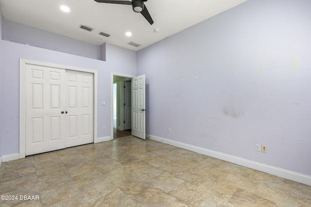 unfurnished bedroom with ceiling fan and a closet