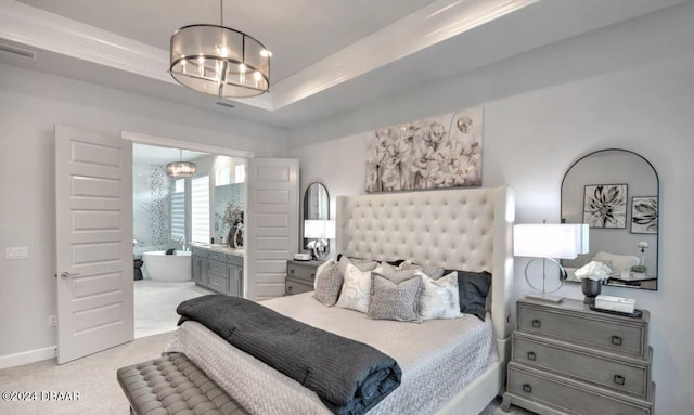 bedroom with ensuite bathroom, light carpet, an inviting chandelier, and a raised ceiling