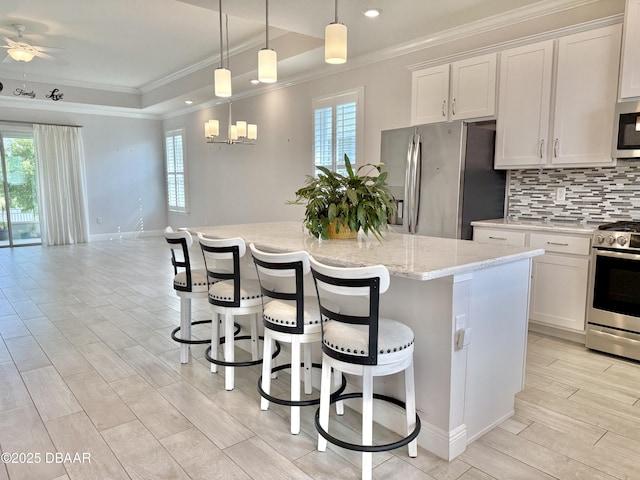 24 Shear Water Trl, Ormond Beach, FL 32174 - kitchen featuring appliances with stainless steel finishes, crown molding, plenty of natural light, tasteful backsplash, and a kitchen island