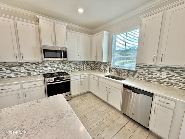 24 Shear Water Trl, Ormond Beach, FL 32174 - kitchen featuring appliances with stainless steel finishes, a sink, white cabinets, crown molding, and backsplash
