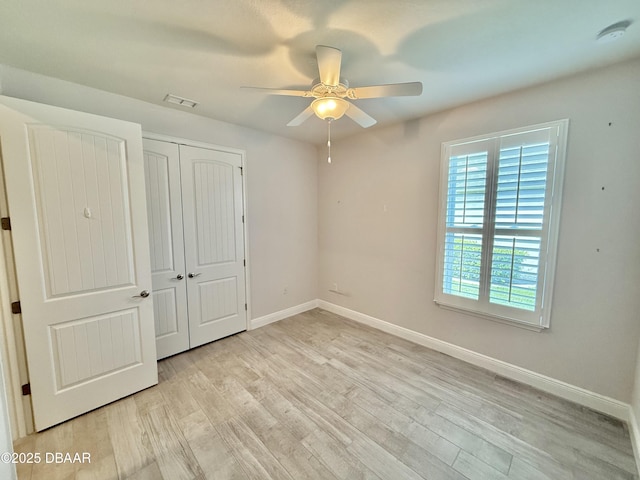 24 Shear Water Trl, Ormond Beach, FL 32174 - unfurnished bedroom featuring multiple windows, light wood-style floors, a closet, and baseboards