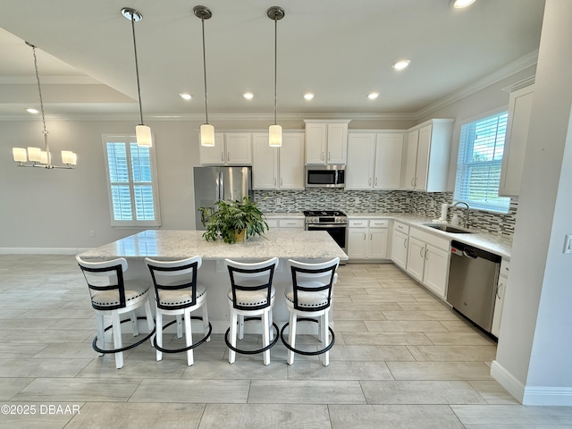24 Shear Water Trl, Ormond Beach, FL 32174 - kitchen with appliances with stainless steel finishes, ornamental molding, a kitchen island, a sink, and backsplash