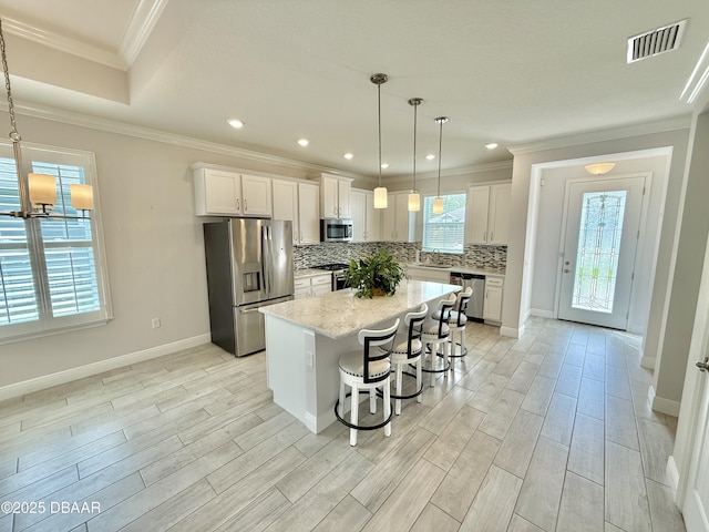24 Shear Water Trl, Ormond Beach, FL 32174 - kitchen featuring appliances with stainless steel finishes, decorative backsplash, a sink, a breakfast bar area, and a kitchen island